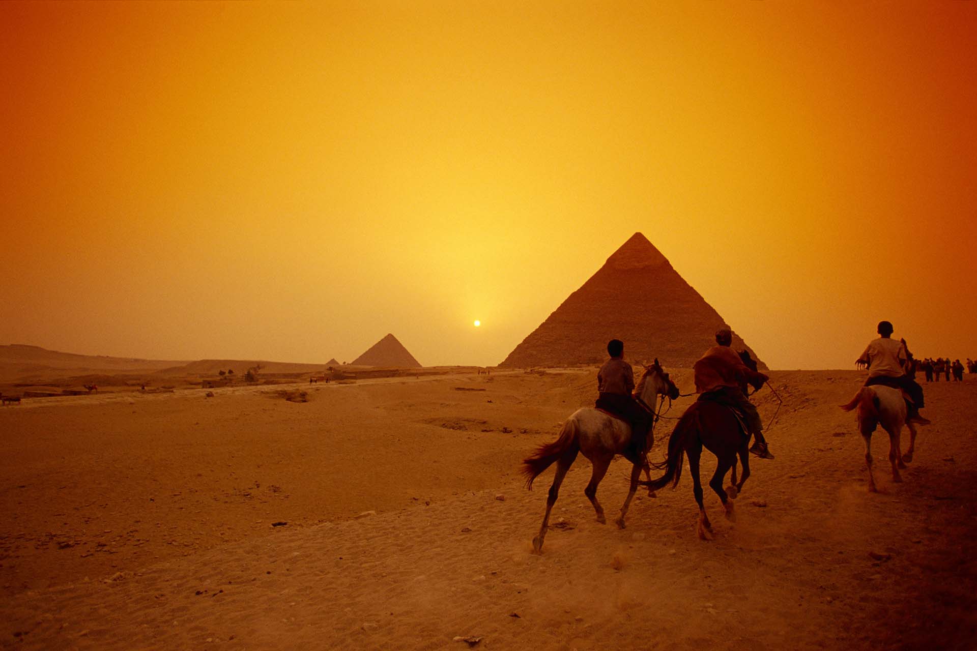 Pyramids in Giza at sunset with riders