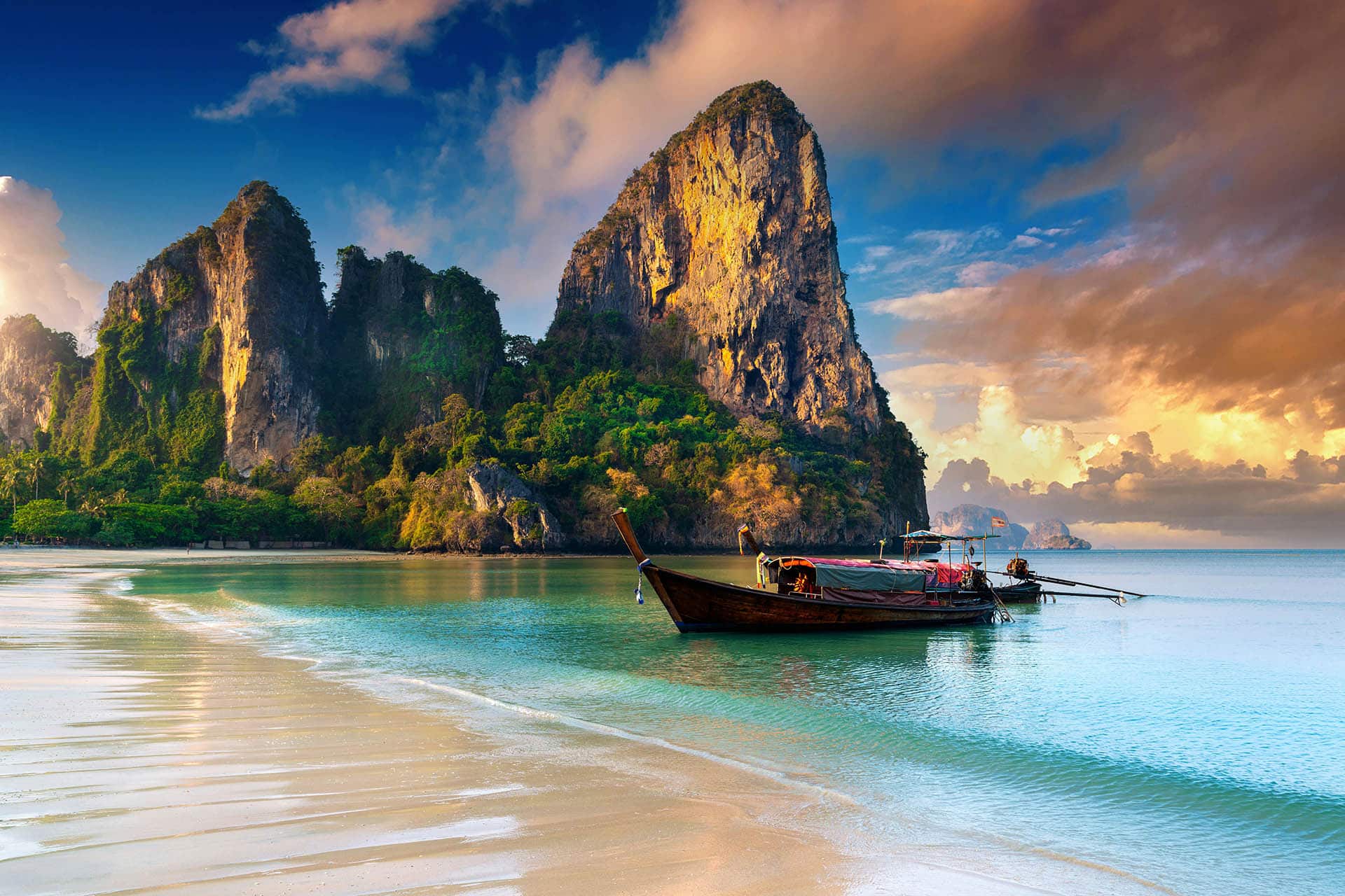 Serene beach with a traditional boat in Thailand.